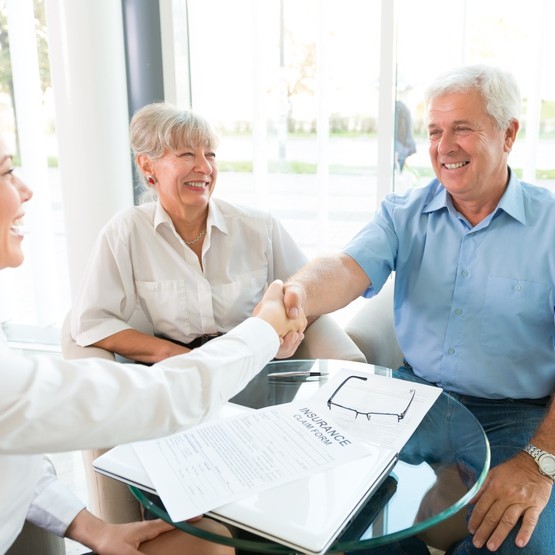 Senior Couple Shaking Hand With Insurance Agent